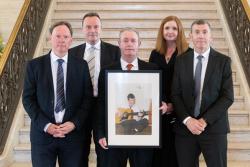 Front row: Shane McCormac (left), Paul McCormac (right), and Conor McCormac holding a photograph of their late father, John. Back row: Ian Jeffers, Commissioner for Victims and Survivors, and Jayne Brady, Head of Civil Service.