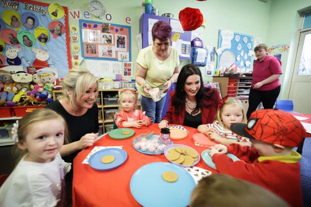 First Minister MIchelle O'Neill and deputy First Minister Emma Little-Pengelly chatting to children attending Shankill Women's Centre childcare facility. 