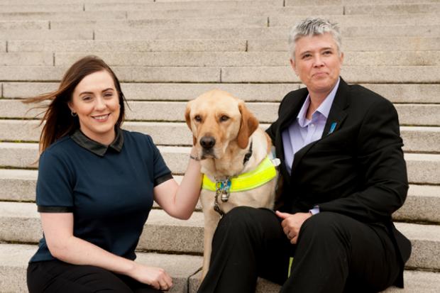 Junior Minister, Megan Fearon with Diane Marks and her quide dog Morris outside Parliament Buildings.