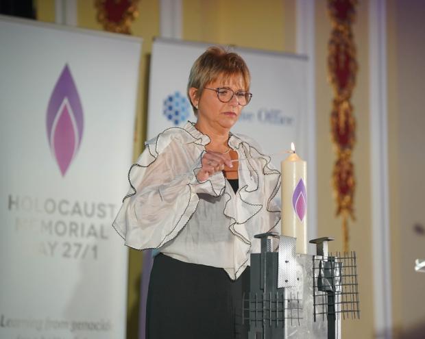 Photograph: Lu Lawrence pictured lighting the candle at the regional HMD 2025 commemoration in Belfast City Hall.