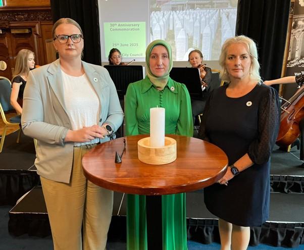 Junior Ministers Aisling Reilly and Pam Cameron with Azra Omerbegović, survivor of the Srebrenica genocide.