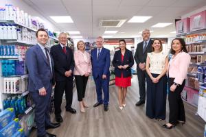 Group image of eight people standing in a pharmacy - NIO Minister Matthew Patrick; Secretary of State, Hilary Benn MP; Cathy Harrison, Chief Pharmaceutical Officer at the Department of Health; Health Minister Mike Nesbitt; deputy First Minister Emma Little-Pengelly; Finance Minister John O'Dowd; Leah O’Donnell, Pharmacist at Carryduff Pharmacy; Marie Smith, Chair of Community Pharmacy NI. 